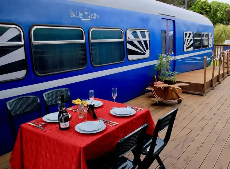 A table set with red linen on the Blue Train’s outdoor deck