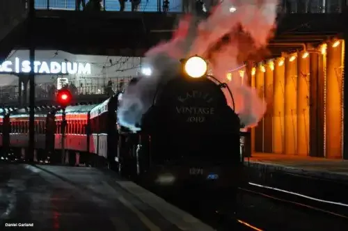 A steam locomotive at night under the lights of Wellington Railway Station